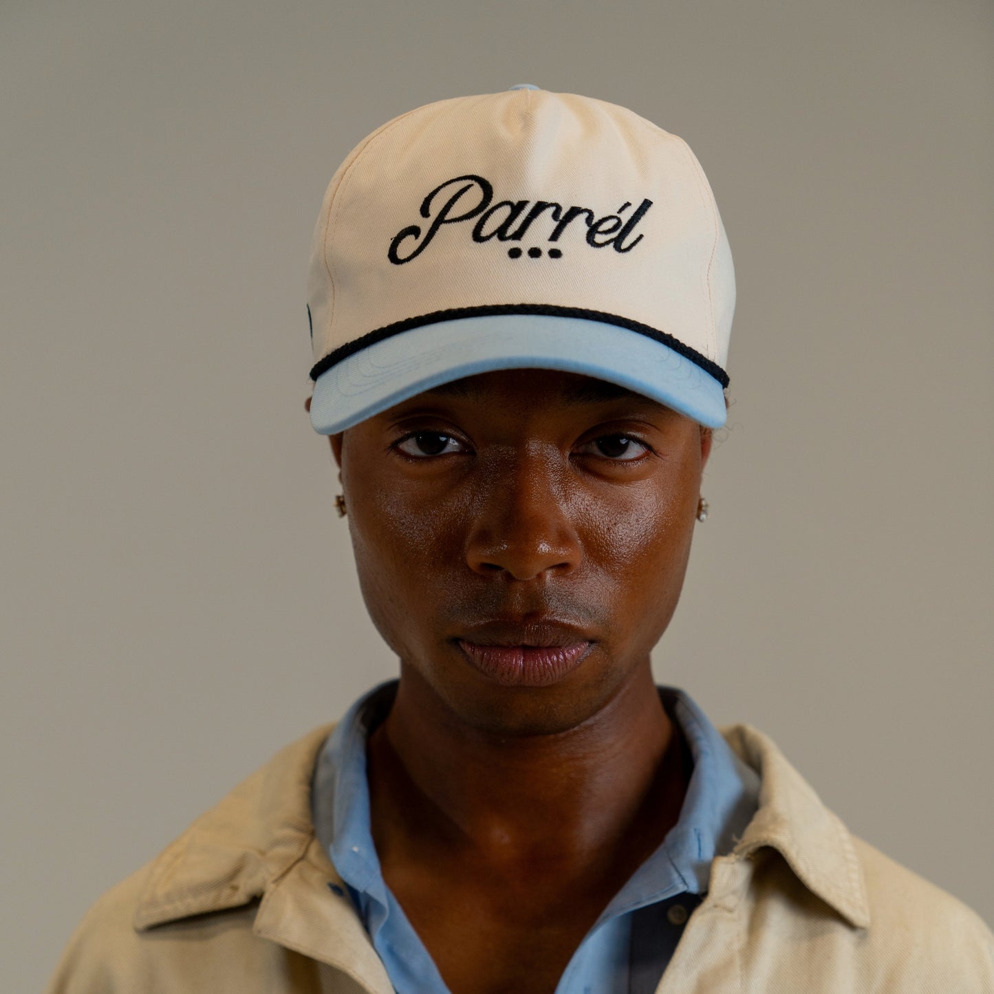 Person wearing a beige cap with 'Parrél' branding against a plain background